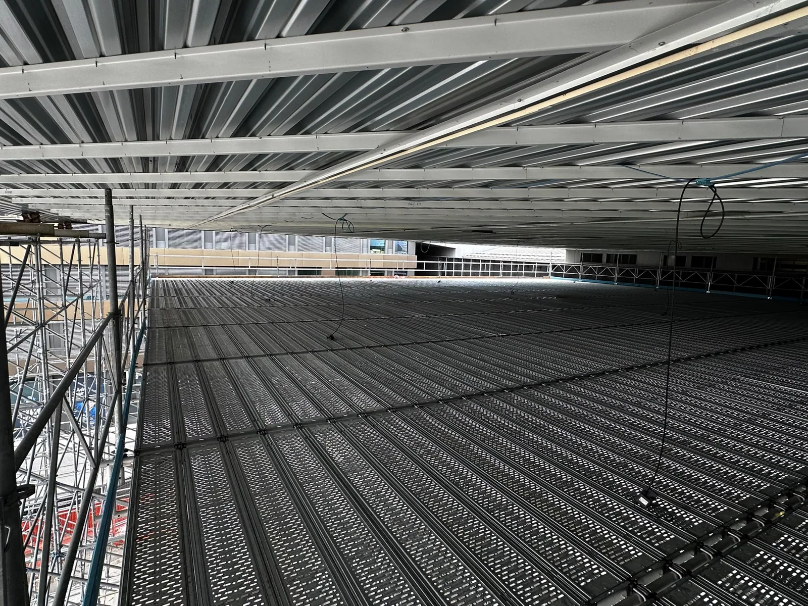 Arbeitsplattform unter einer Hallendecke Arbeitsplattform unter einer Hallendecke. Die Gerüstkonstruktion bildet zusammenhängende Arbeitsflächen für Montagen und Arbeiten unter dem Hallendach. Referenzfoto der Isufi Gerüste AG.